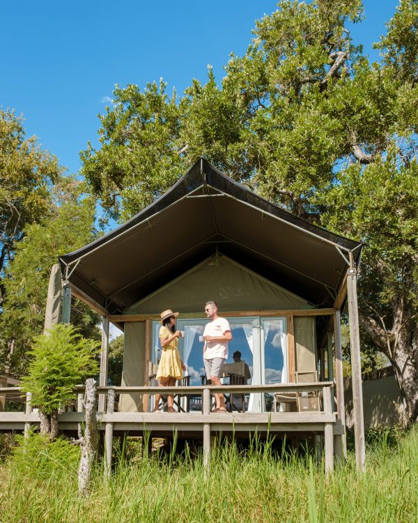 couple on safari in South Africa, Asian women and European men at a tented camp lodge during the safari. Couple of men and a woman are on vacation in South Africa
